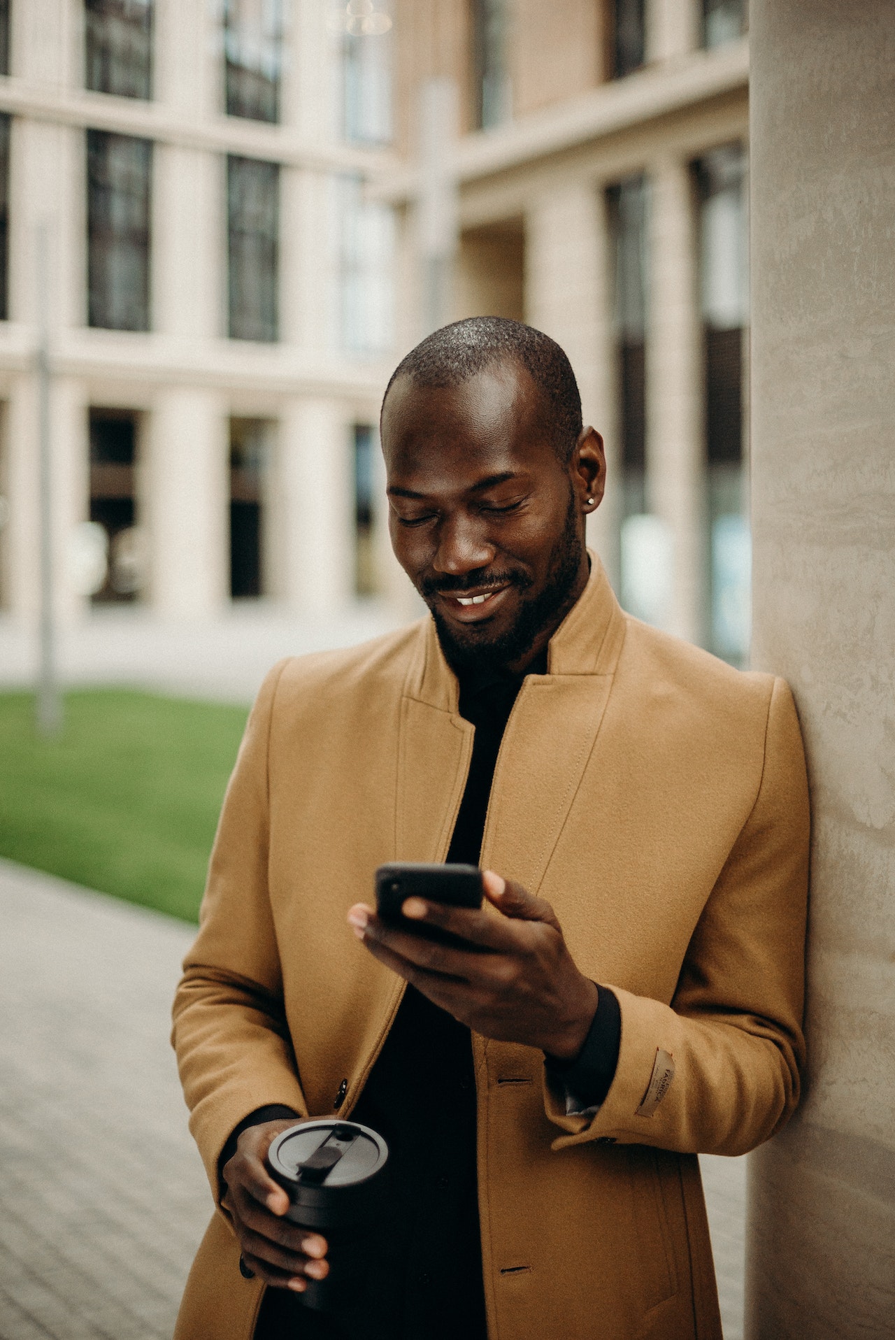 man in the city checks his smartphone, for airport taxi booking information.