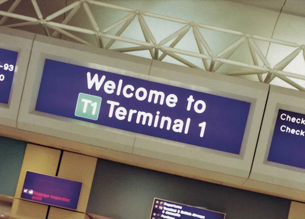 A sign at Manchester Airport welcoming travelers to Terminal 1, a popular arrival point for those seeking a cheap taxi from Liverpool to Manchester Airport